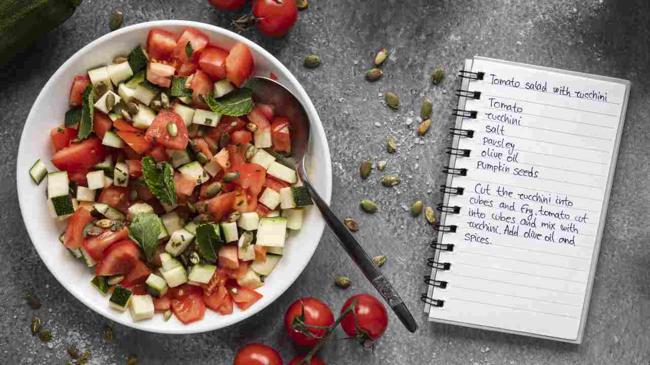 A table top view with a Mediterranean dish and a planner